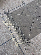 Hand-braided edging and tassels on black and ivory kilim runner