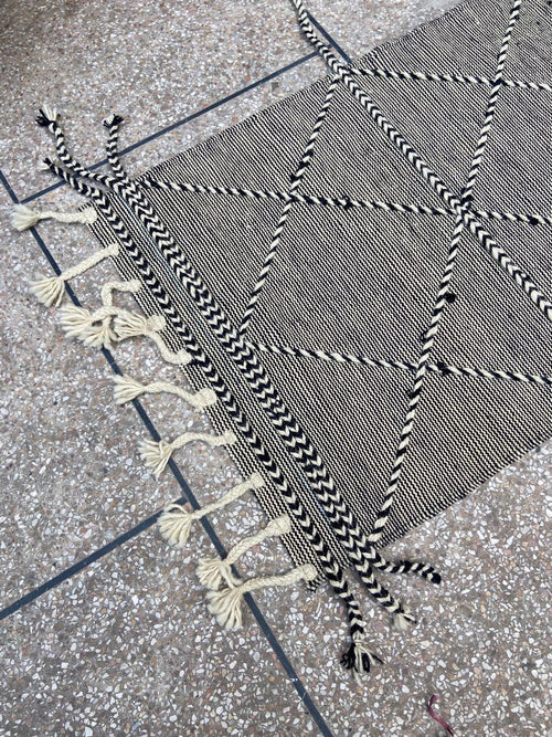 Hand-braided edging and tassels on black and ivory kilim runner
