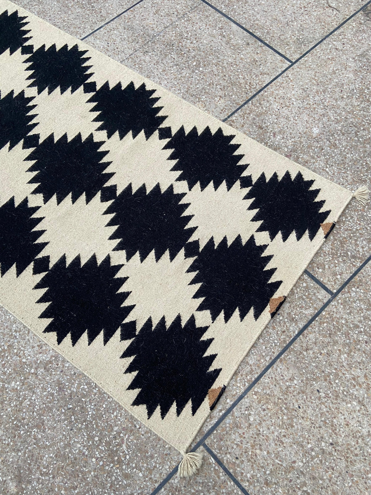 Angled view showing the geometric pattern of the wool kilim runner