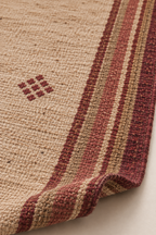 Close-up of burgundy medallion and striped handwoven wool kilim edge