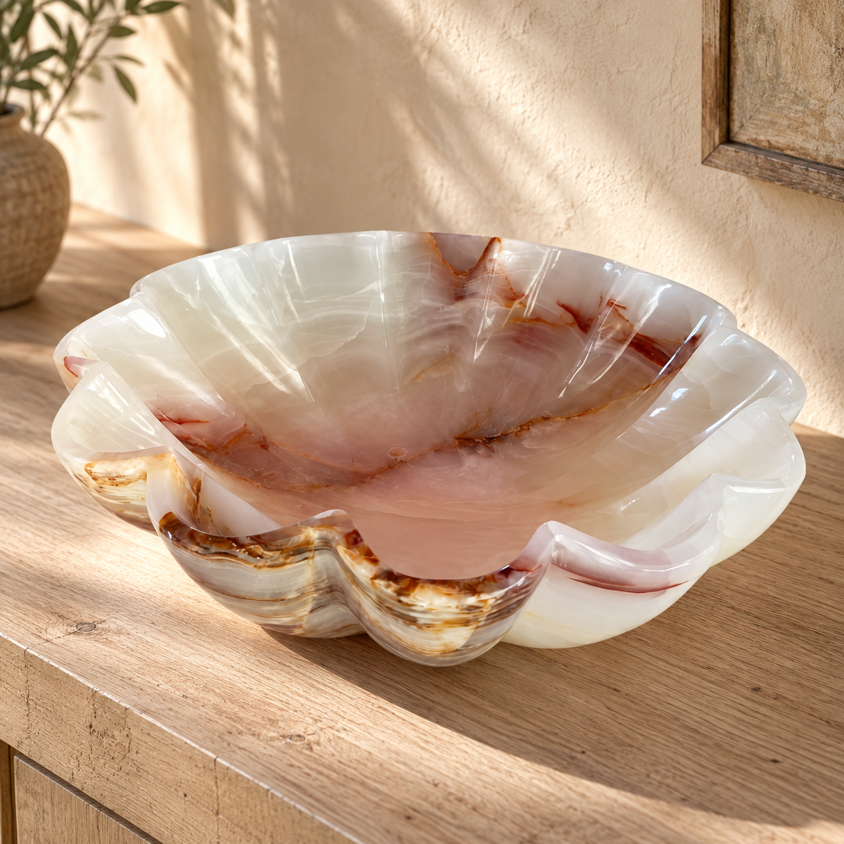 Styled presentation of scalloped natural stone bowl on a wood console