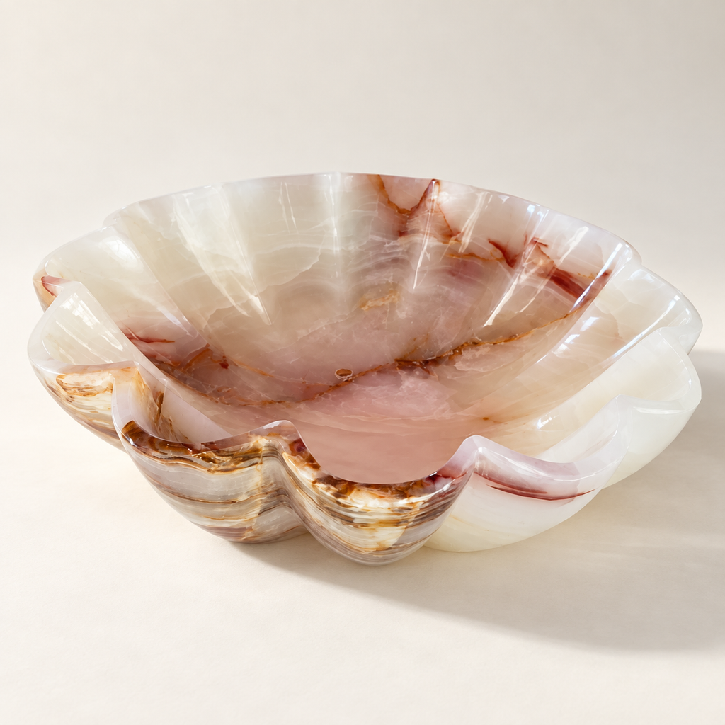 Studio presentation of scalloped natural stone bowl in cream, blush and amber tones