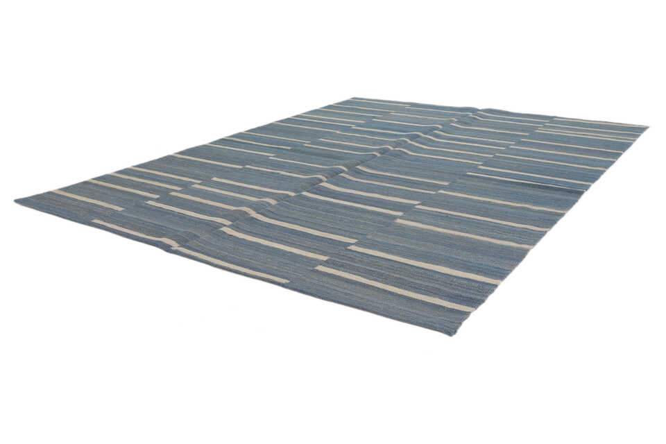 Denim blue and ivory coastal flatweave rug viewed from an angle