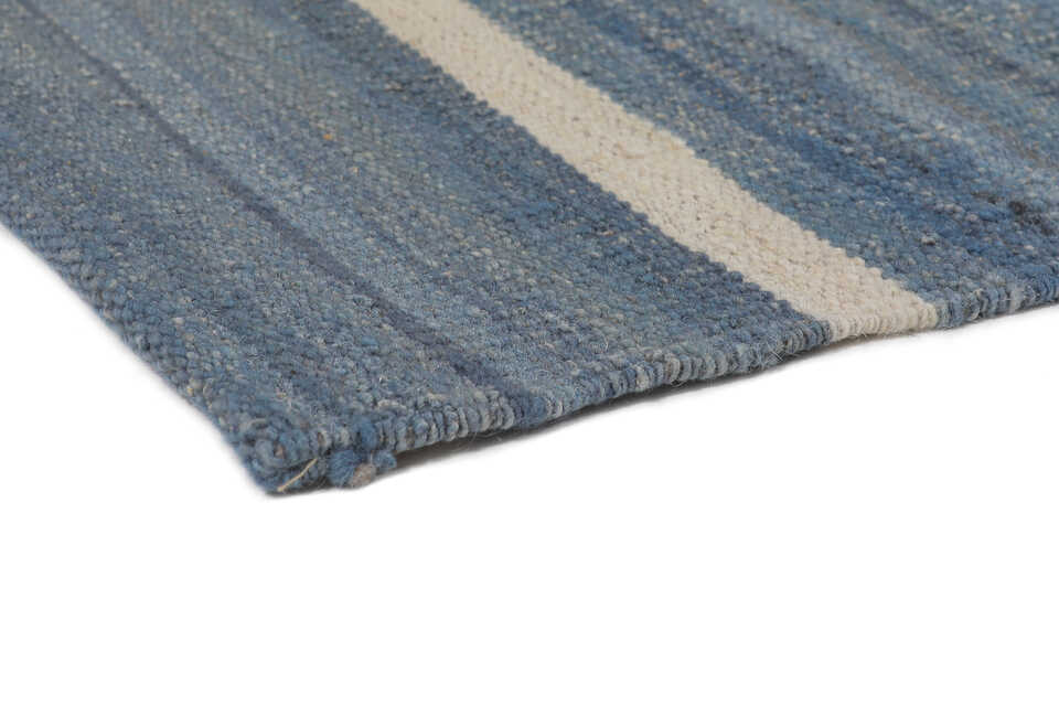 Hand-finished edge of denim blue and ivory wool kilim rug