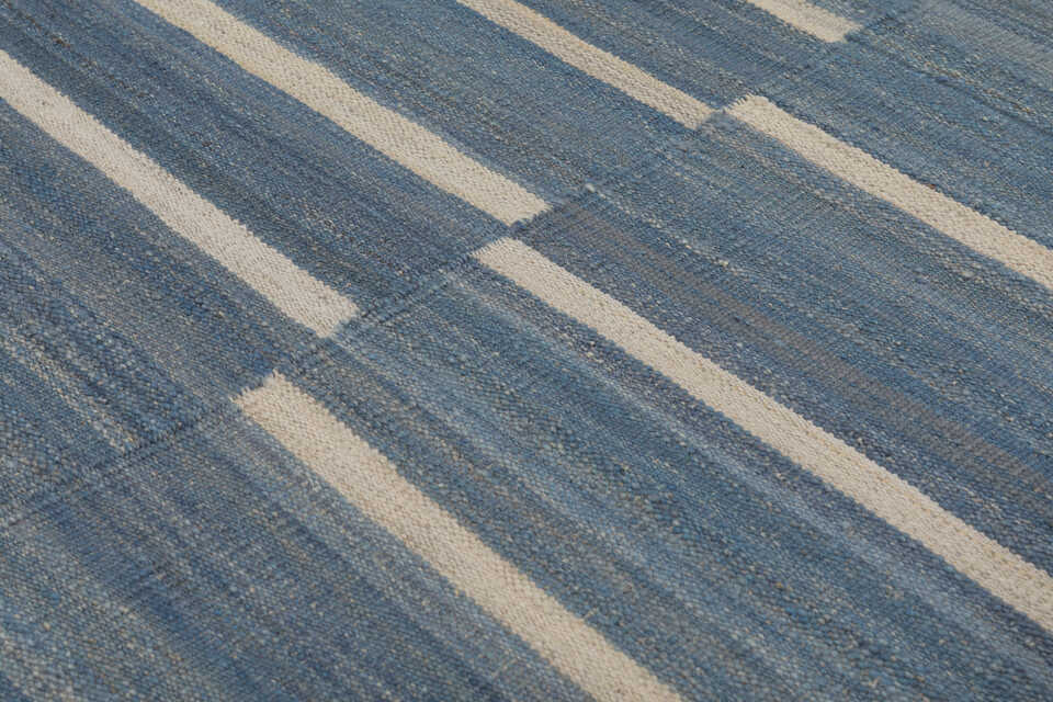 Close-up of irregular ivory stripes on denim blue flatweave