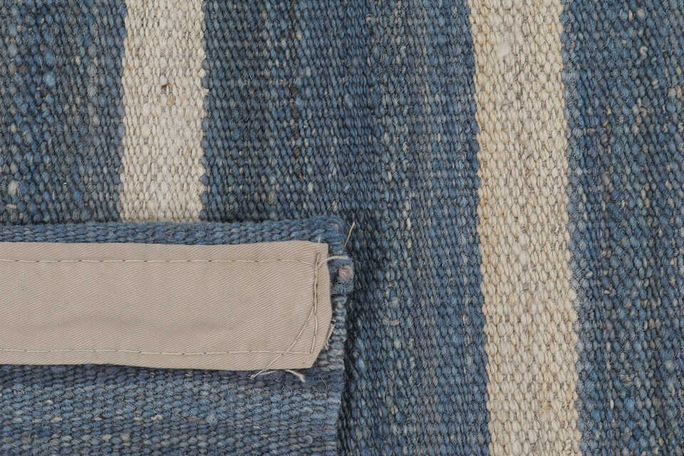 Reverse construction detail of denim blue striped kilim rug