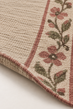 Angled close-up of the flatwoven wool kilim edge and floral detail