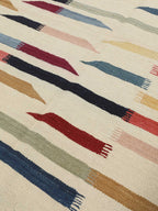Close-up of burgundy, blue and rust abstract stripes on wool rug