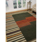 Olive and rust modern striped wool kilim rug styled in a living room