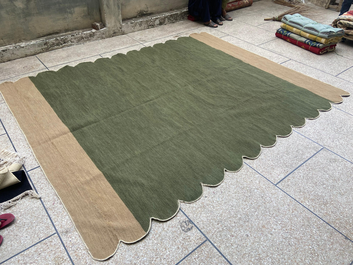 Handwoven olive wool rug showing natural texture and scalloped shape