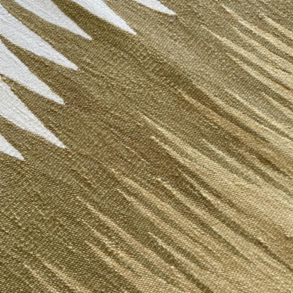 Close-up of sand beige and olive handwoven flatweave texture