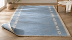 Sky blue and ivory geometric handwoven wool rug in a bright room