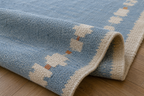Close-up of sky blue and ivory wool runner with rust accents