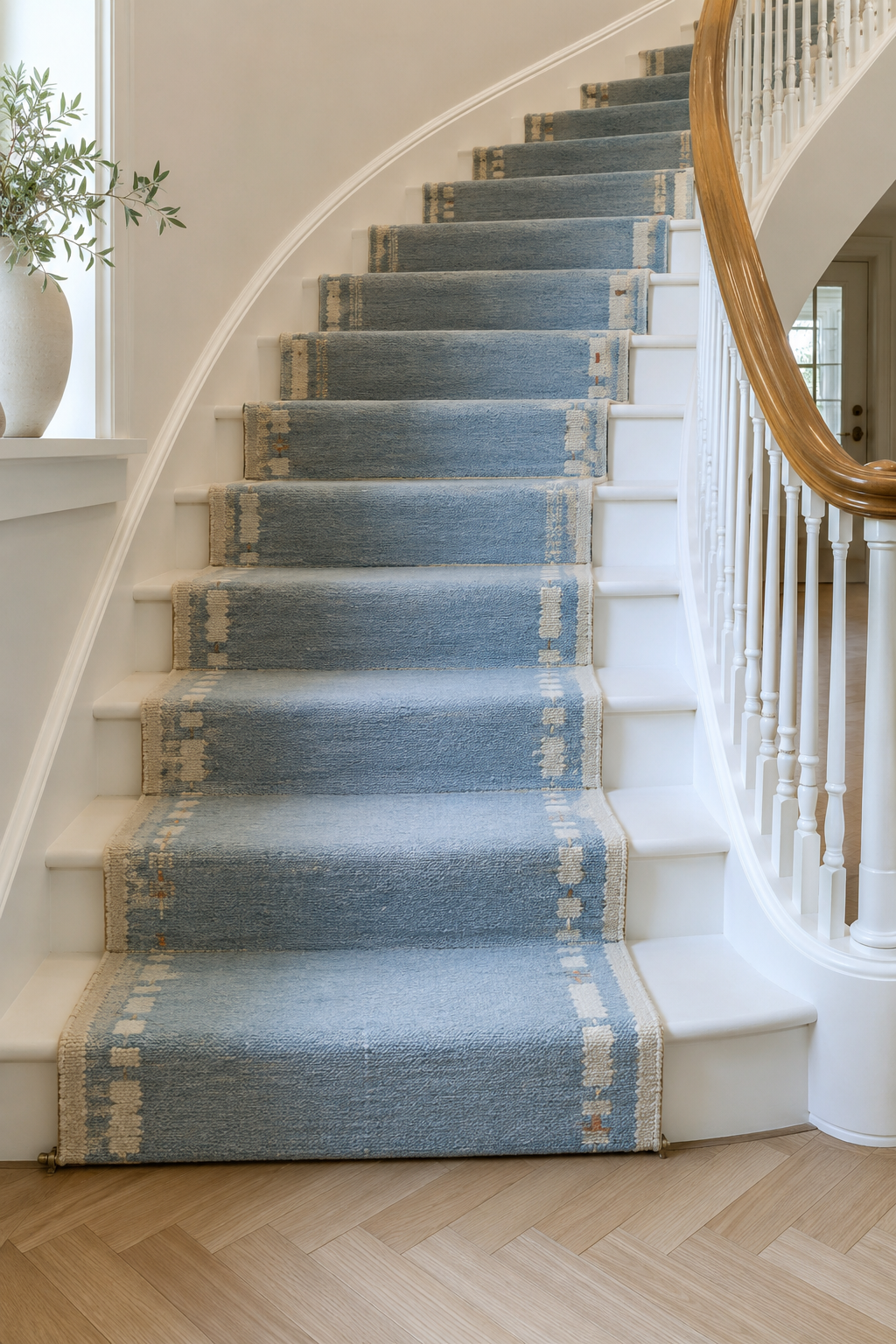 Sky blue wool runner with ivory side motifs installed on a staircase