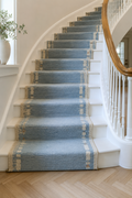 Sky blue wool runner with ivory side motifs installed on a staircase